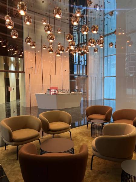 A stylish interior with comfortable armchairs, pendant lights, and a reception area in commercial premises.