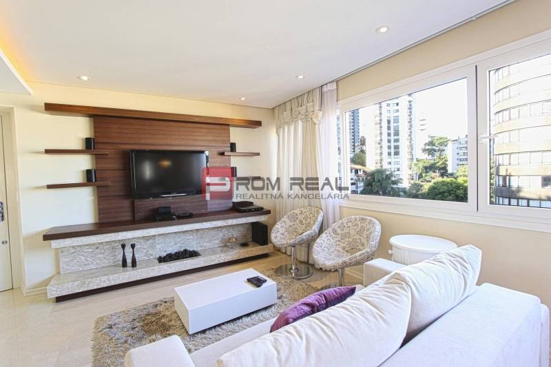 Living room in a 3-room apartment, with a TV and large windows offering a view.