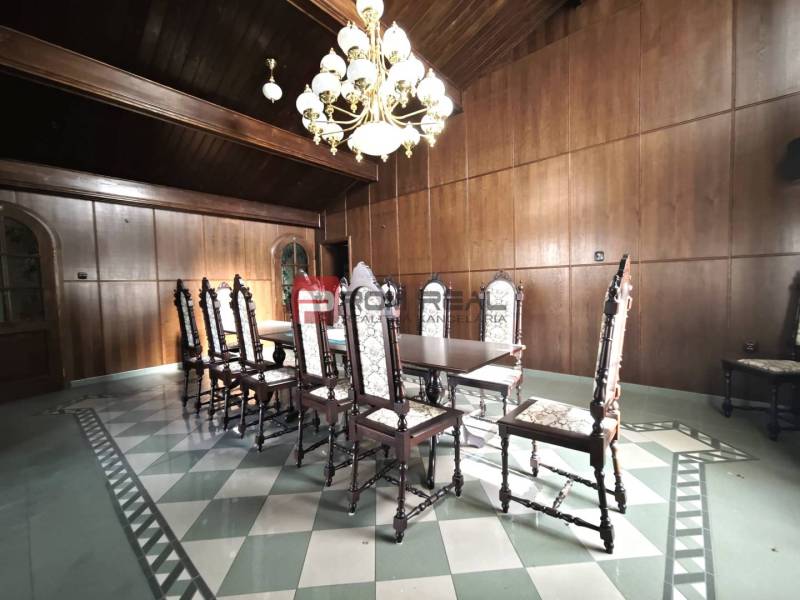 Dining room with a wooden ceiling and paneling, a massive table on Ľ. Podjavorinská, an impressive building.