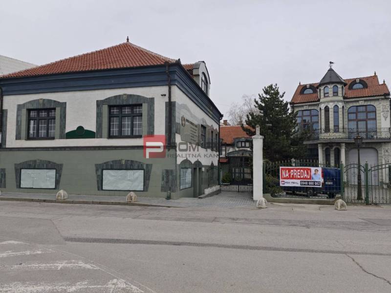 A building on Ľ. Podjavorinská Street, marked for sale, with historical style architecture.