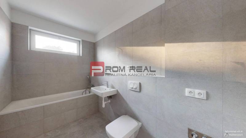 A bathroom in a 2-room apartment with a bathtub and a sink in a neutral color scheme.