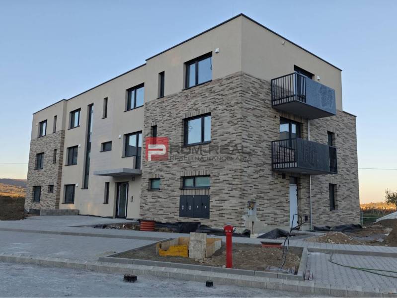 A new building with a brick facade on the street in Pezinok includes 2-room apartments.