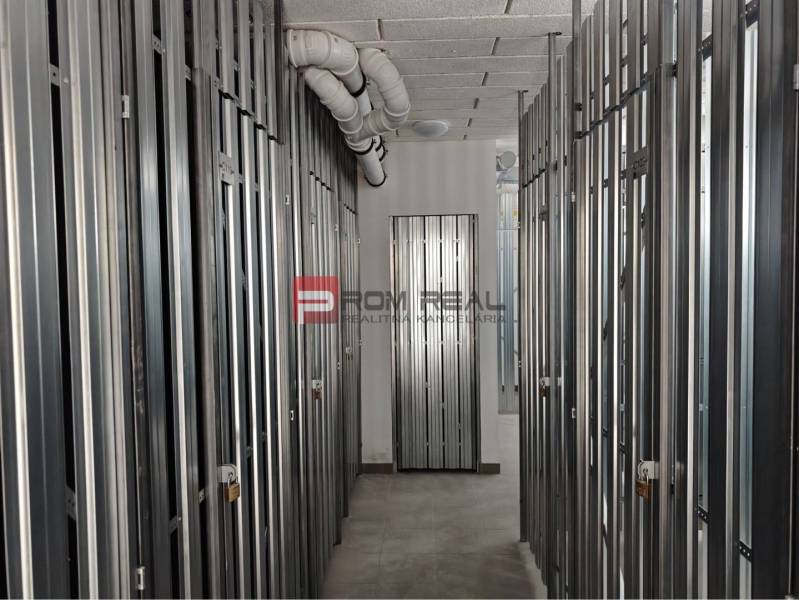 Storage spaces with metal doors and pipes on the ceiling in a 2-room apartment.