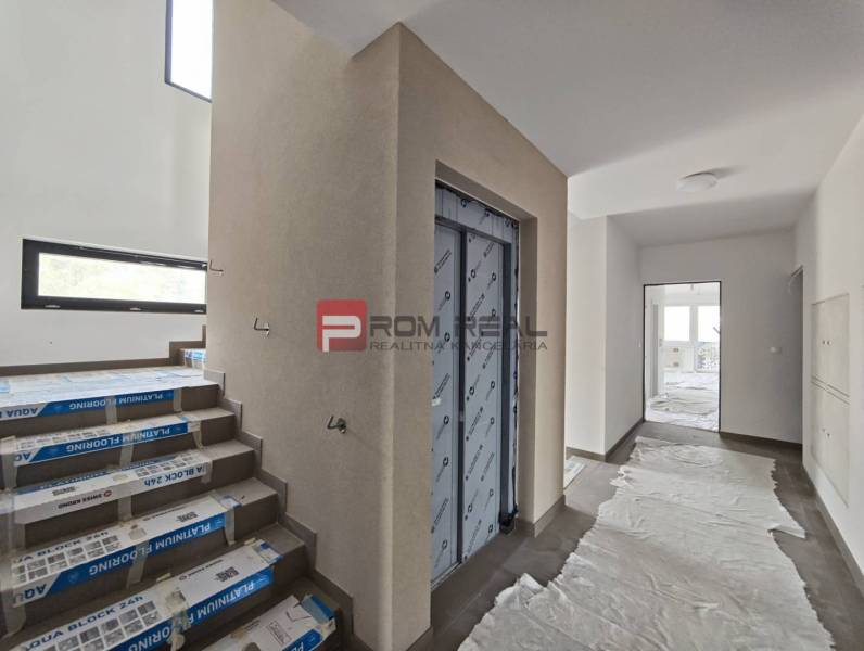 Hallway with an elevator, staircase, and plastic covering in a 2-room apartment.
