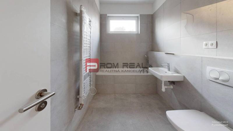 Bathroom in a 2-room apartment with a sink, toilet, and window for natural light.