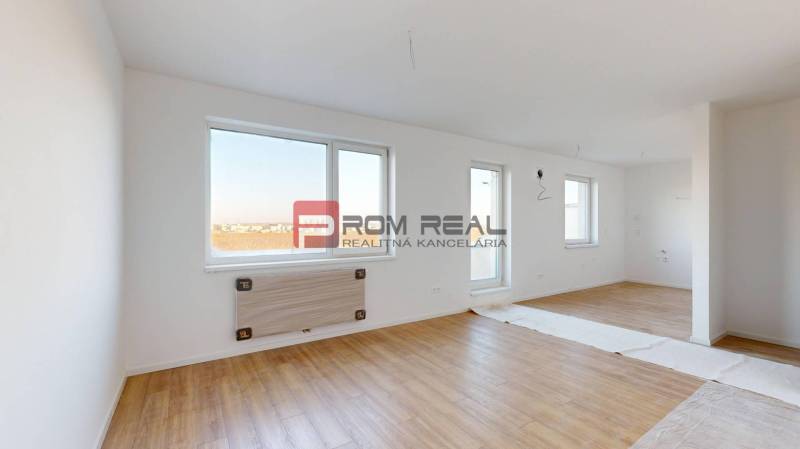 Spacious interior of a 2-room apartment with wooden flooring and white walls.