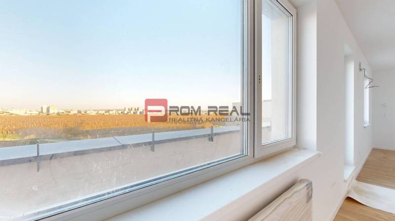 A room in a 2-room apartment with a view of the surroundings through a large window.