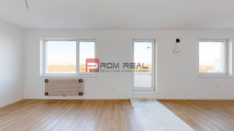 Empty room with wooden floor and windows in a 2-room apartment.