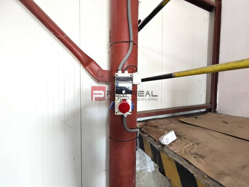 Interiors of warehouses and halls with a red pipe and electrical equipment.