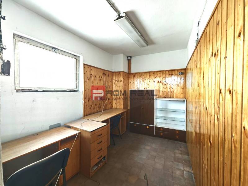 Office space in a warehouse with wooden paneling and furniture.