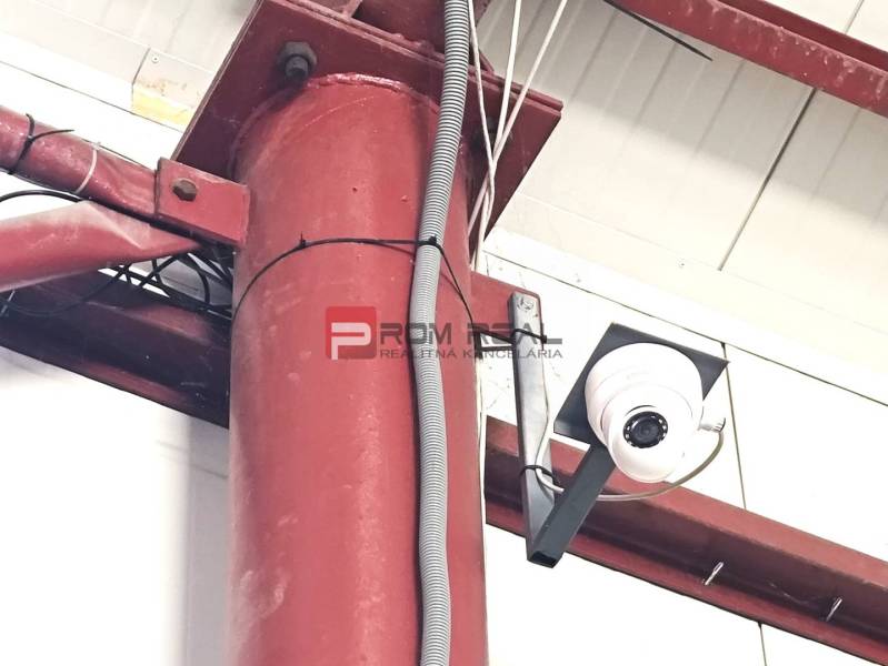Security camera inside warehouses and halls, detail of a red metal pillar.