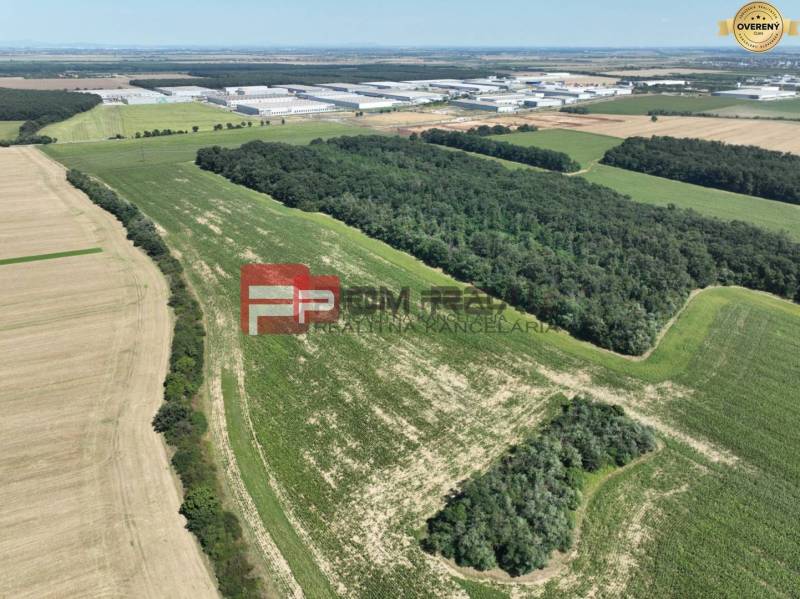 Aerial view of agricultural and forest land near Senecká Street and buildings.