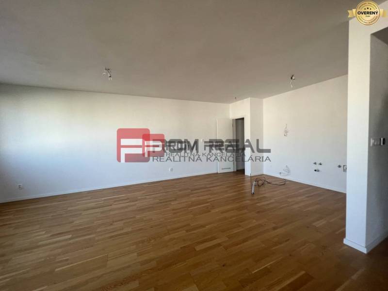 Spacious interior of a 4-room apartment with wooden flooring and white walls.