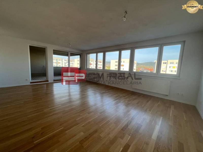 A large spacious room with light parquet floors, windows with a view, 4-room apartment.