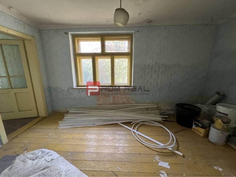 A room with a wooden floor, old doors, building materials, used for renovation. Properties - housing.