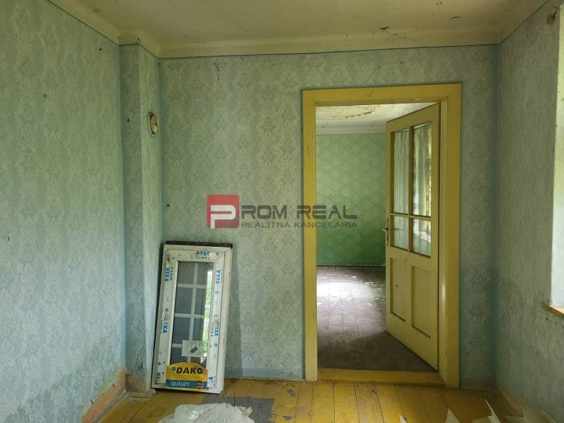Interior with wallpaper and old flooring, Properties - living. It adds a rustic atmosphere.