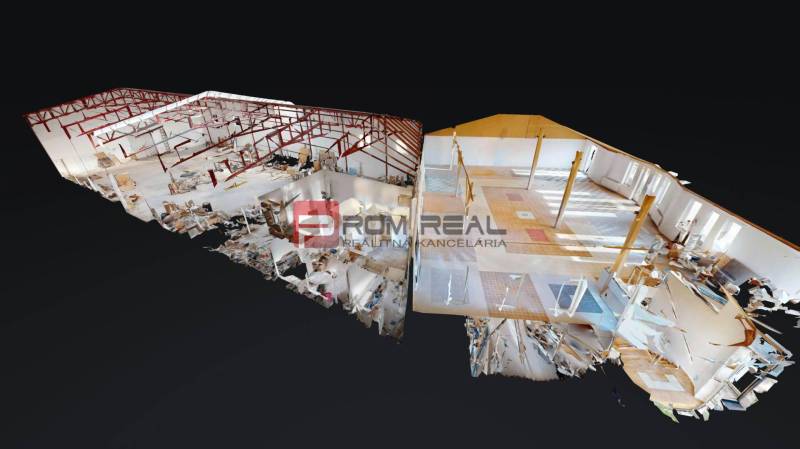 The interior of the building with open spaces, red frame structures, and diverse flooring.