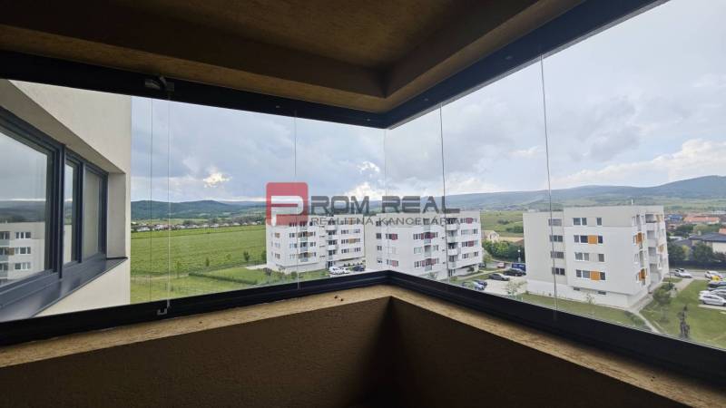 View from the balcony of a 4-room apartment over green fields and surrounding buildings in Pezinok.