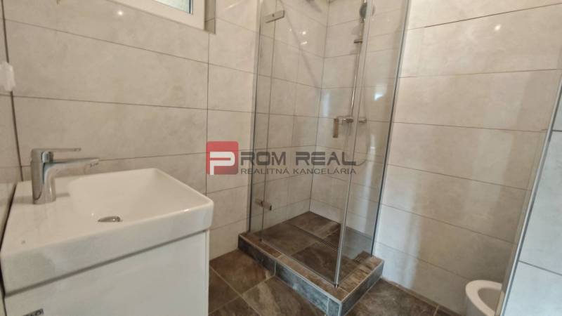 A bathroom in a 4-room apartment with a shower and a sink.