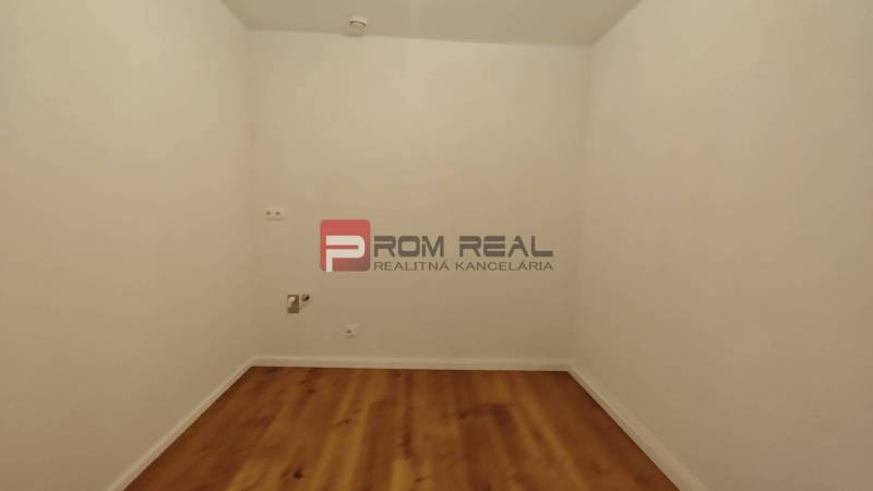 A room with white walls and a wooden floor in a 4-room apartment.
