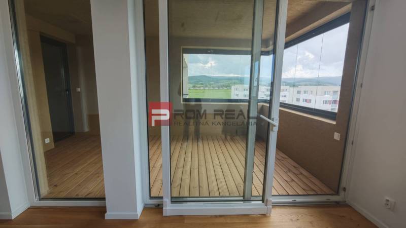 Glass doors lead to the loggia in a 4-room apartment with a view of the hills.