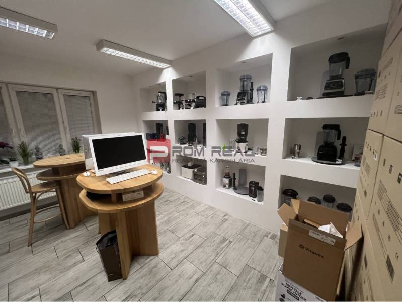 Commercial premises with displayed blenders, wooden tables, and cardboard boxes.