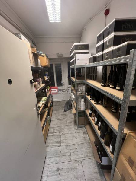 A narrow room with shelves on both sides full of bottles and packages.