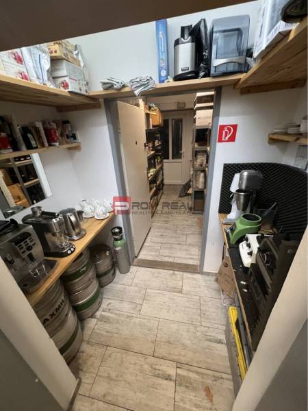 Storage space with shelves, barrels, and coffee machines in commercial premises.