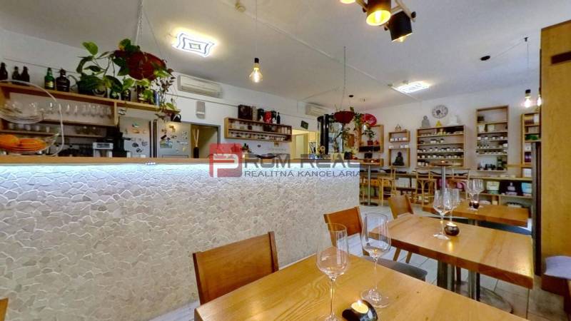 Interior of commercial spaces with wooden tables and a bar, decorative elements, and shelves.