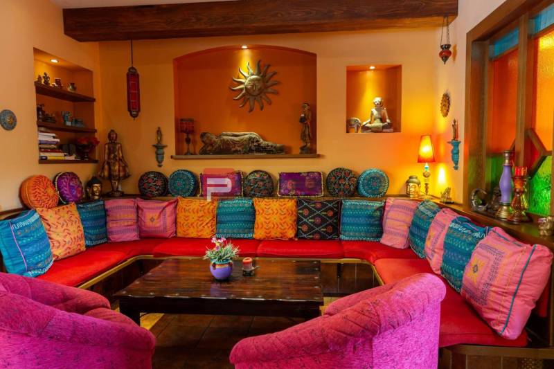 A colorful room with comfortable cushions and wooden decorations in hotels and guesthouses.