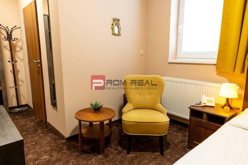 A hotel room with a chair, a table, a lamp, and a telephone, suitable for relaxation.