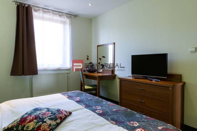 Room with a bed, table, and television in hotels and guesthouses.