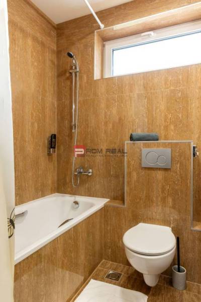 A bathroom with a bathtub and toilet in hotels and guesthouses, tiled with brown tiles.