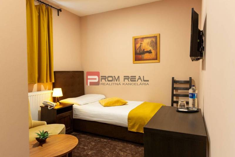 Cozy room with a bed, chair, and television, ideal for hotels and guesthouses.