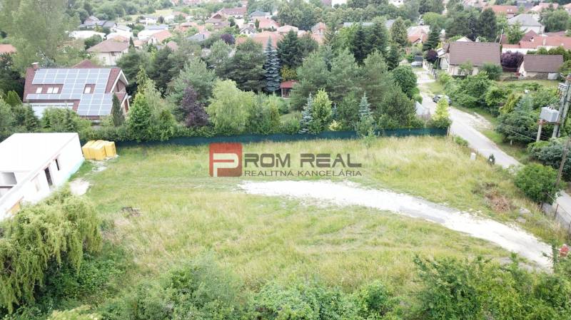 Residential plots in Marianka on Štúrova Street surrounded by greenery and family houses.