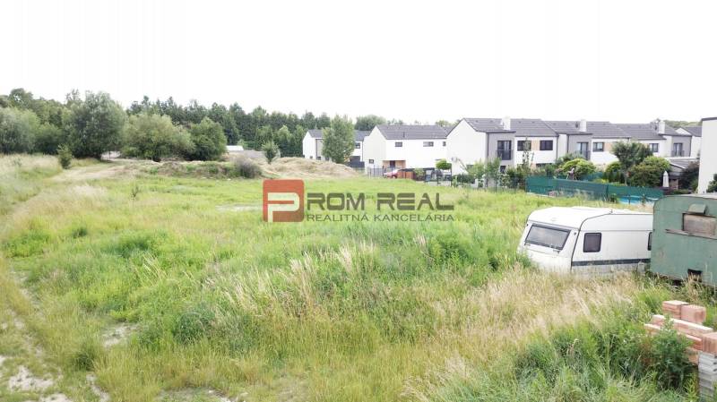 Greenery and caravans near family houses on residential plots in Marianka on Na Ovsisku Street.
