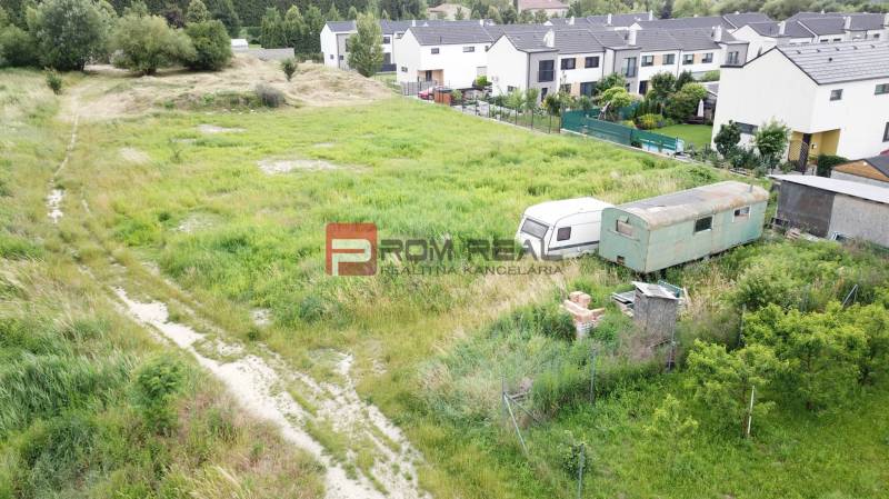 Land - housing in Marianka on Na Ovsisku, grassy terrain with caravans.