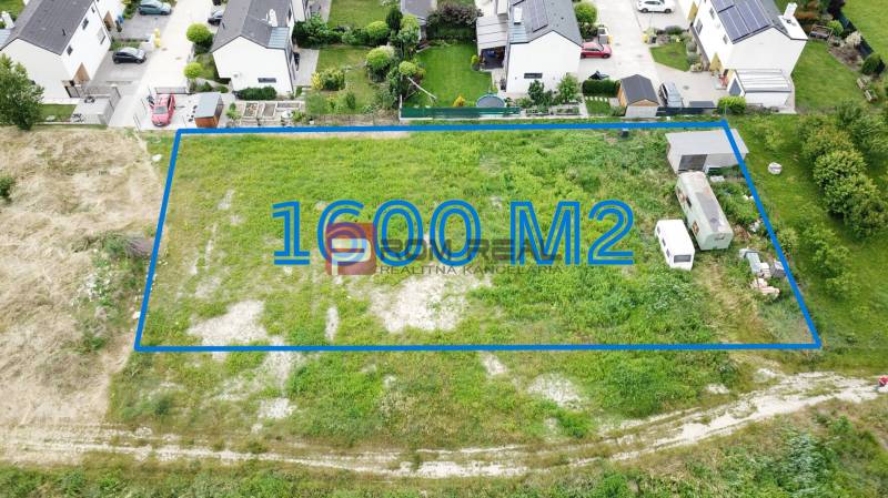 Land - housing in Marianka, Na Ovsisku, 1600 m², with surrounding modern houses.