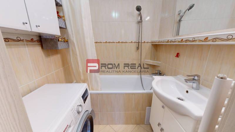 Bathroom with shower, washing machine, and sink in a 3-room apartment.