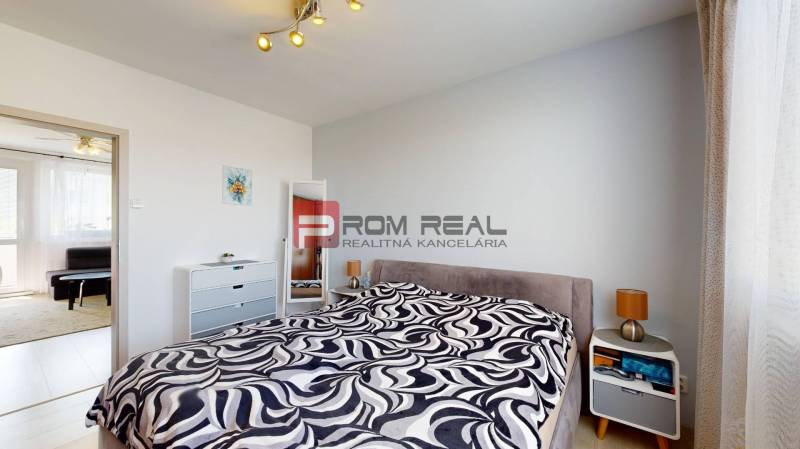 Bedroom with a bed, mirror, and nightstand in a 3-room apartment.