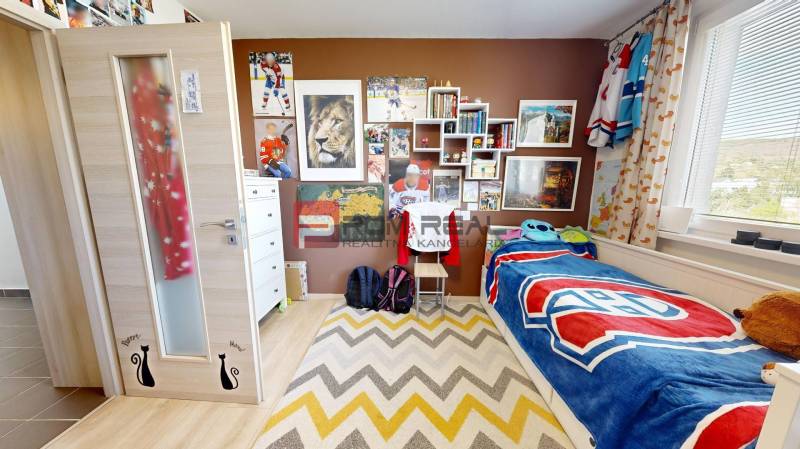 Children's room with hockey motifs in a 3-room apartment, decorations and a bed with a colorful throw.