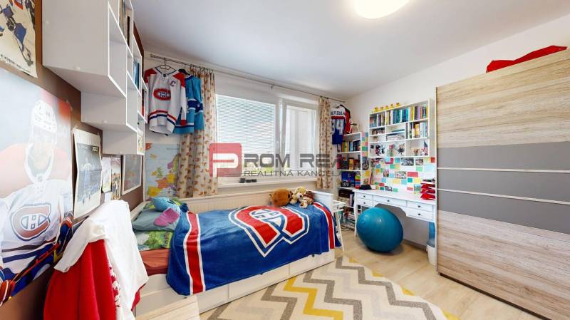 A children's room with hockey decorations, a bed, a desk, and a shelf in a 3-room apartment.
