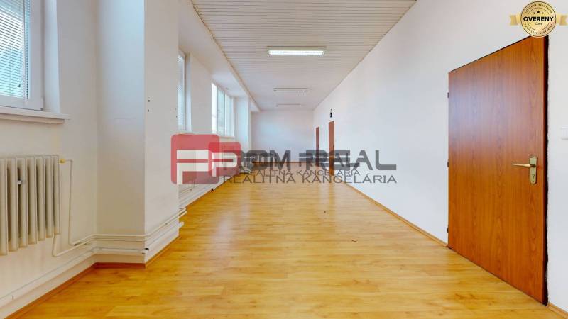 A spacious corridor with wooden flooring and doors in storage and hall areas.