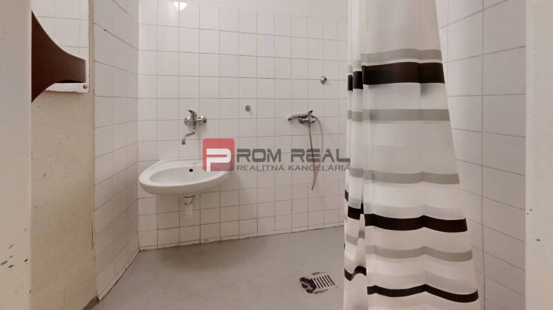 A bathroom with a shower and a sink in the premises of warehouses and halls.