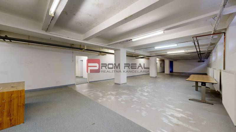 Interior of warehouse spaces with bare walls and several tables. Warehouses and halls.
