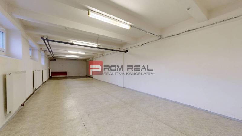 Interior of a warehouse and hall with simple lighting and white walls.