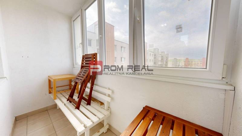 View from the balcony of a 4-room apartment with folding chairs and a table.