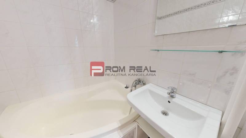 A bathroom with a corner bathtub and a sink in a 4-room apartment.