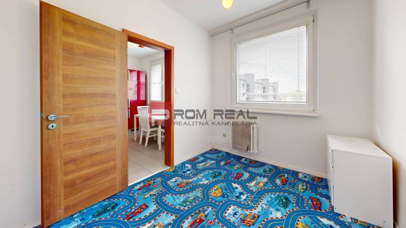 A children's room in a 4-room apartment with a blue carpet and a view from the window.