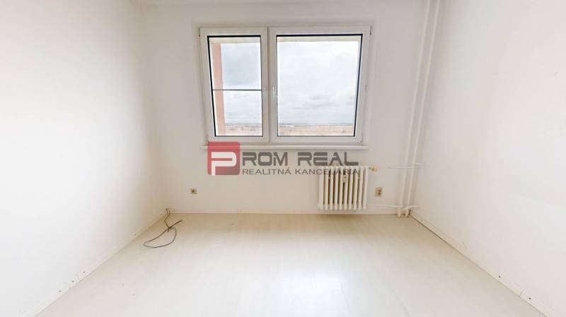 Empty room with a window and a radiator in a 4-room apartment.